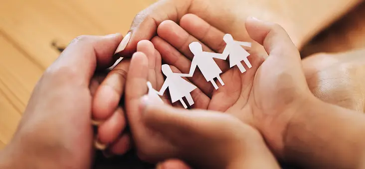Holding Paper Cutout of Family